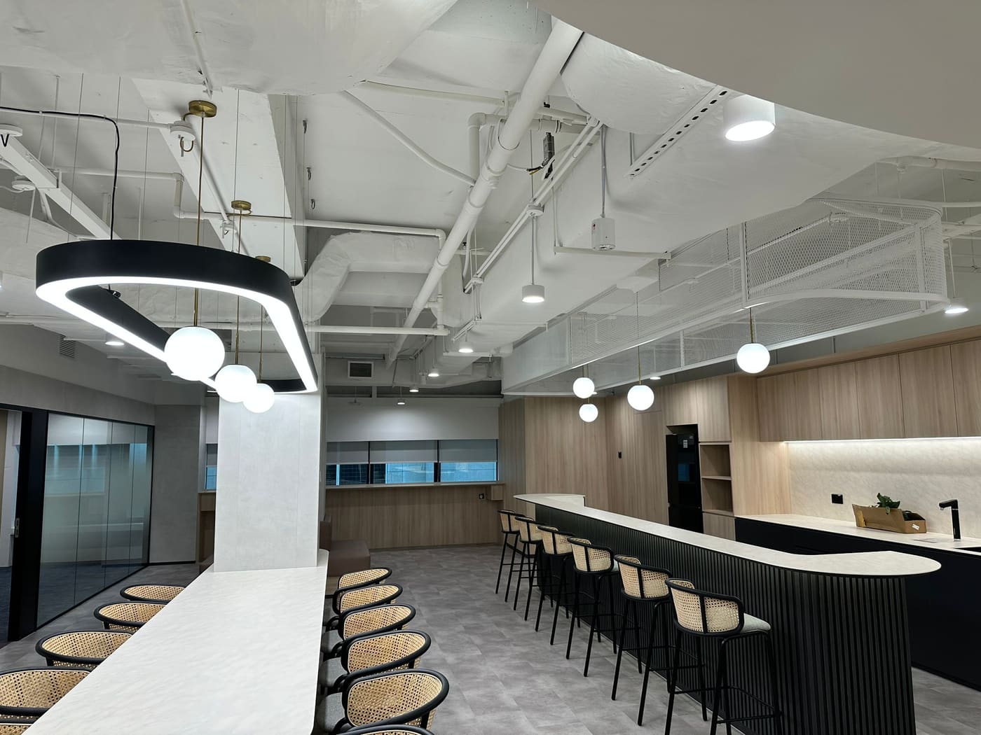Staff café with a ring pendant and track lighting over the counter