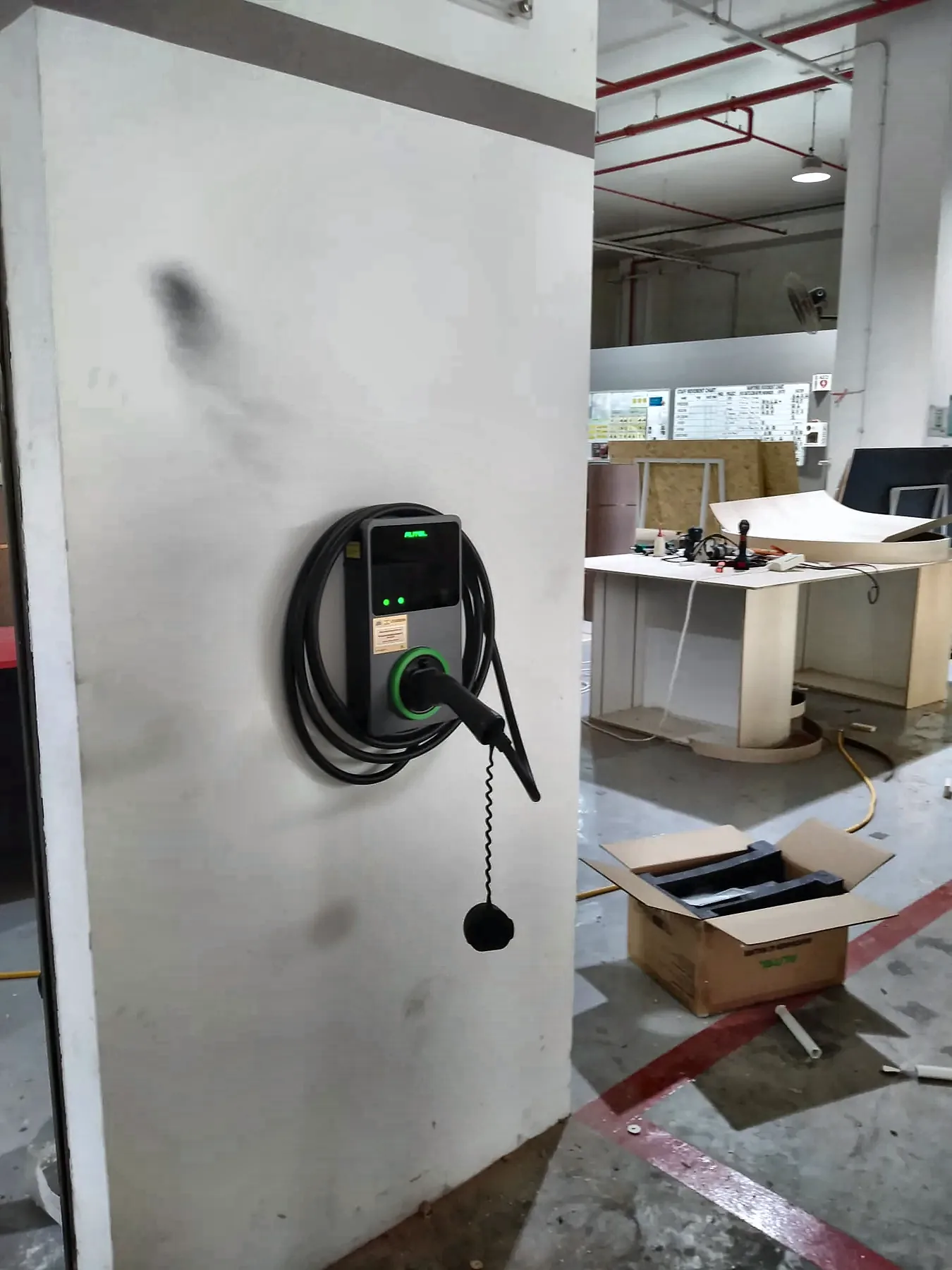 EV charger wall-mounted on a structural column inside a commercial unit during fit-out.