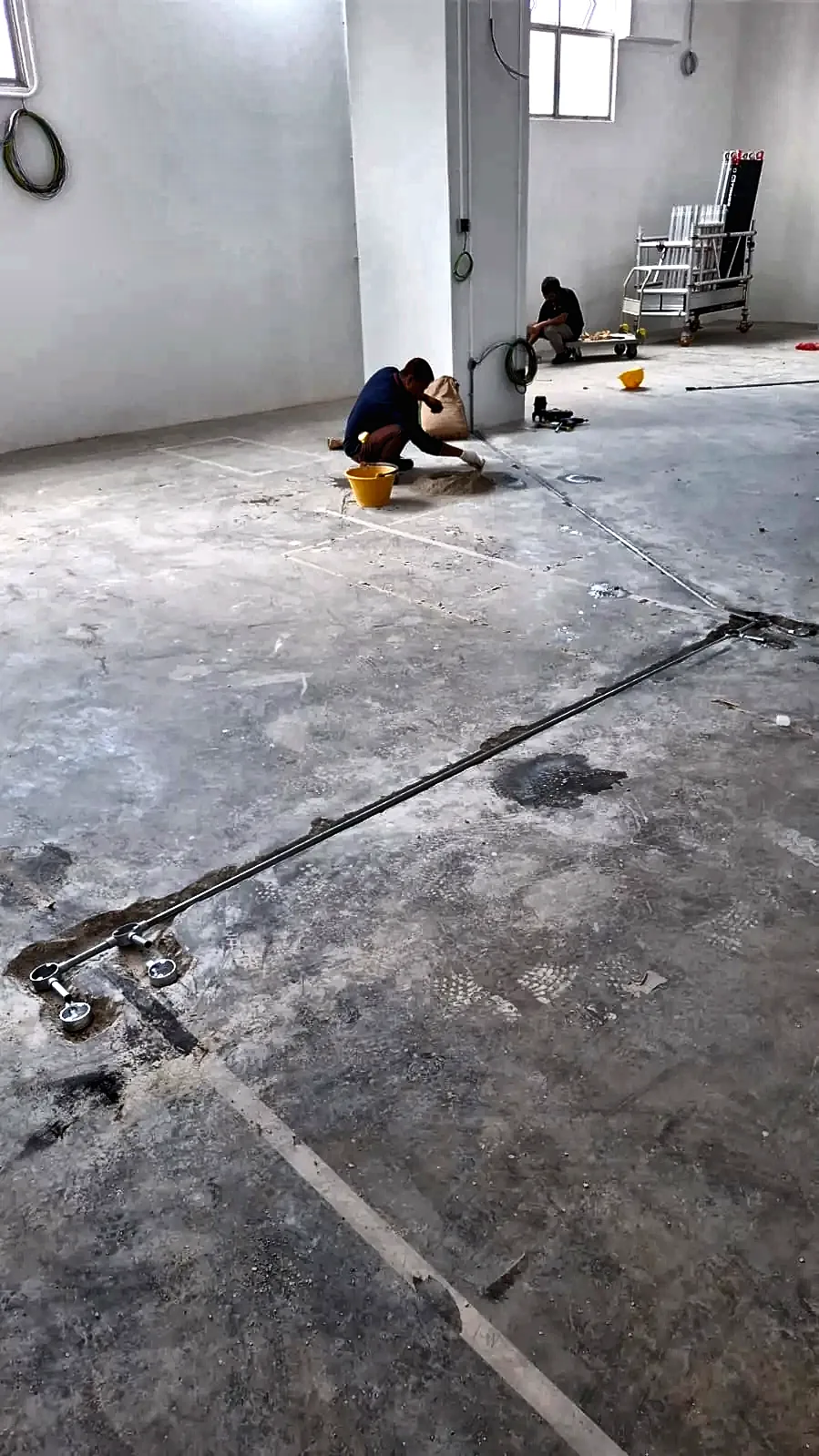 Bare concrete floor with surface conduit runs feeding floor boxes.