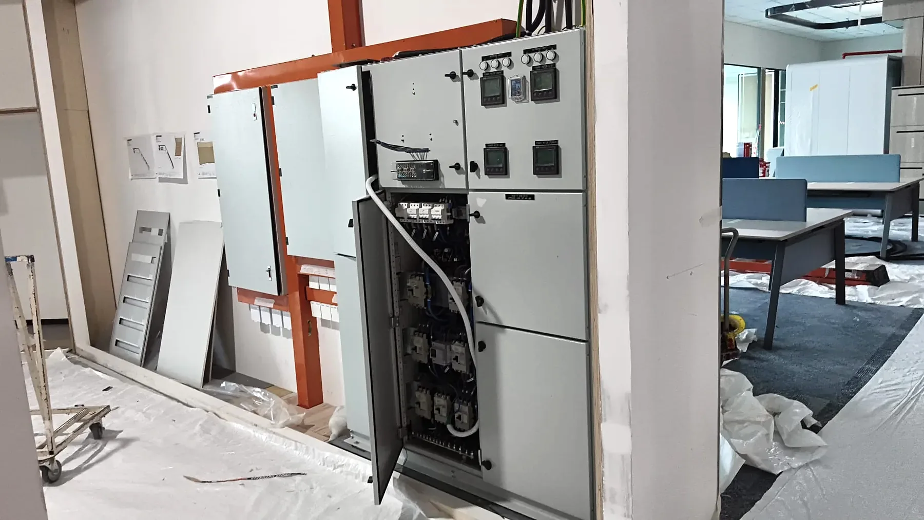 LV switchboard lineup with a cubicle door open showing the internal arrangement